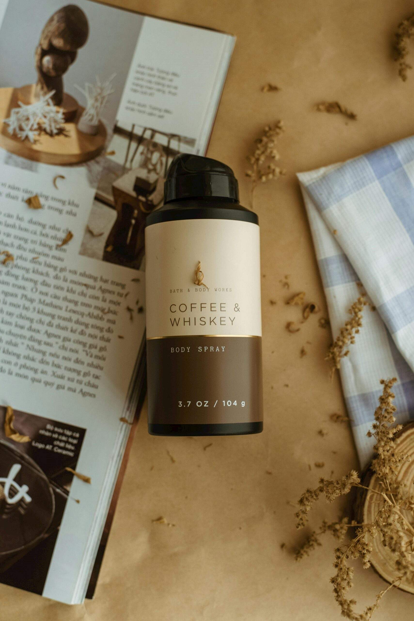 Close-up of a coffee and whiskey-scented body spray on rustic background.